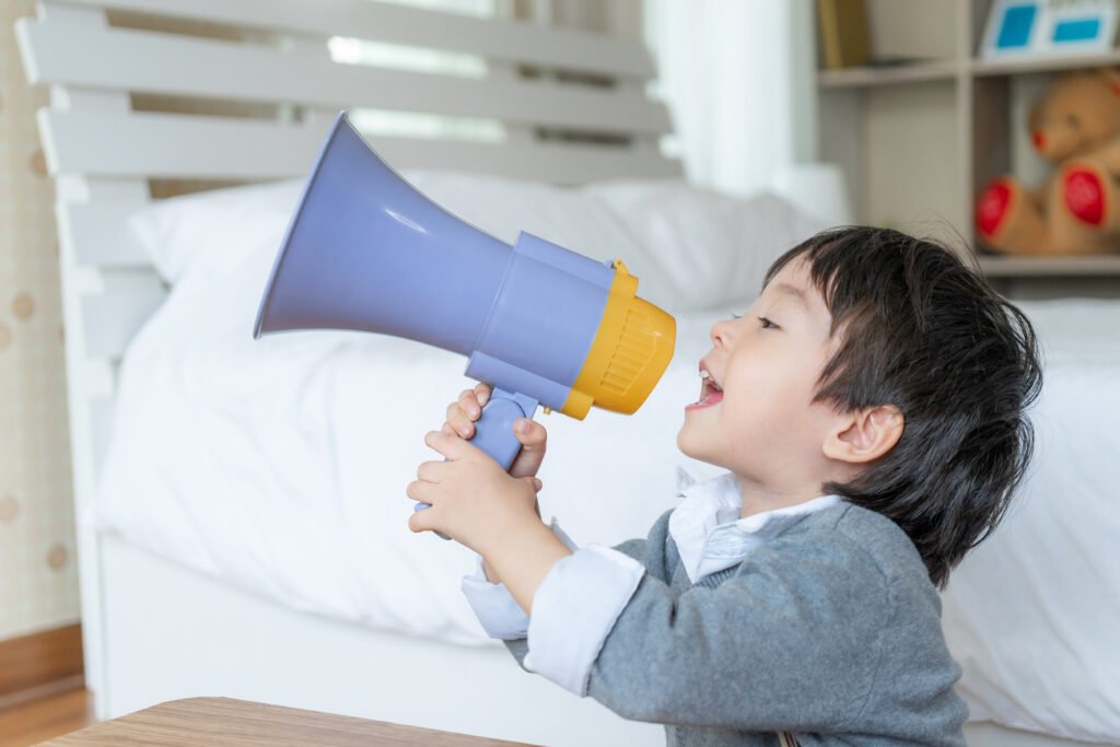 little boy enjoy talking with megaphone