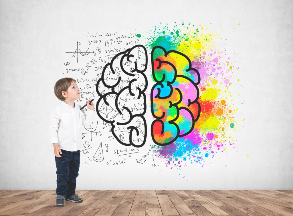 cute little boy white shirt dark jeans holding marker looking upwards concrete wall with colorful brain sketch it